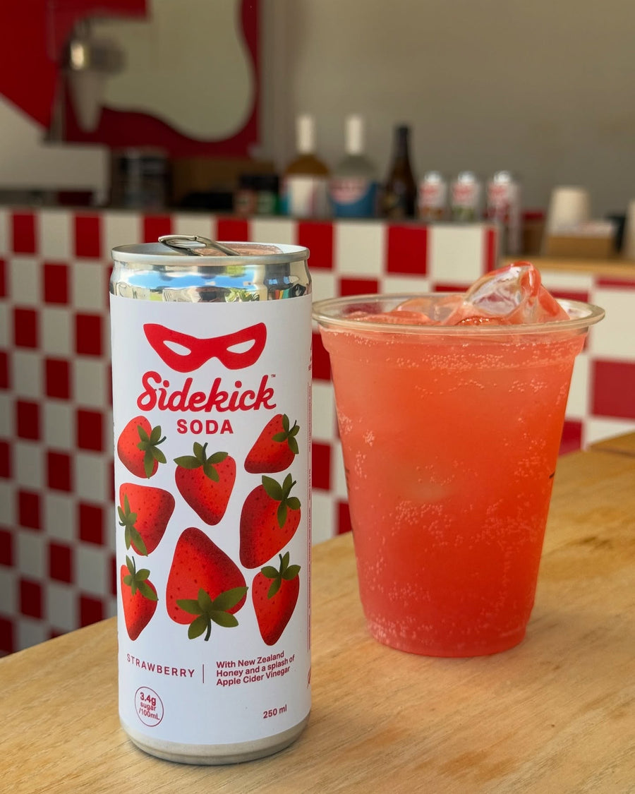 Sidekick Strawberry poured over ice in a glass at a cafe